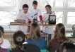 Three students showcasing a physics experiment in front of their classmates