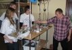 Three students with their teacher experimenting in a physics laboratory